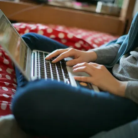 Closeup of a student typing on a laptop